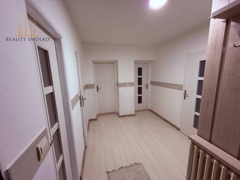 EXKLUZÍVNE: Štýlové bývanie v tichej lokalite Kanaša – po kompletnej r - Chodba rodinného domu s bielymi stenami, podlahou s dreveným dekorom a svetlými dverami.