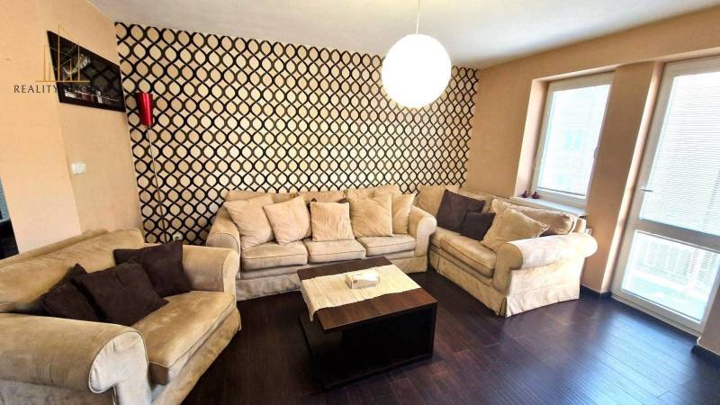 PRENÁJOM 2i, 56 m², PREŠOV- KOMENSKÉHO - Útulná obývacia izba s pohodlnými sedačkami a podlahou s dreveným dekorom v 2-izbovom byte.