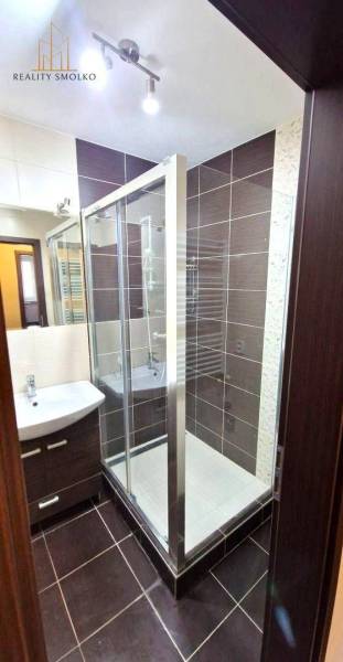 PRENÁJOM 2i, 56 m², PREŠOV- KOMENSKÉHO - Kúpeľňa v 2-izbovom byte s moderným sprchovým kútom a tmavým obkladom.