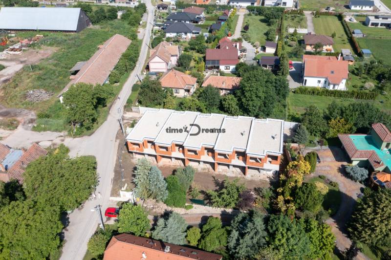 NA PREDAJ ‼️POSLEDNÉ 2 ‼️- 4 izbové radové domy v Ivánke pri Nitre - Výstavba domov, ulica, zeleň a rodinné domy v oblasti, letecký pohľad.