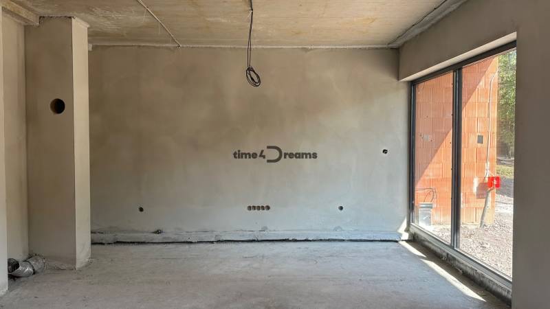 NA PREDAJ ‼️POSLEDNÉ 2 ‼️- 4 izbové radové domy v Ivánke pri Nitre - Stavebný interiér rodinného domu s oknom, surové steny a podlaha v miestnosti.