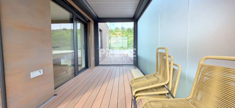 LUXUSNÝ 3i byt,PARKING,CHLADENIE,TERASA,Grand Koliba, Frankovská ulica - Terasa v 3-izbovom byte so sklenenými stenami a pohodlnými drevenými kreslami.