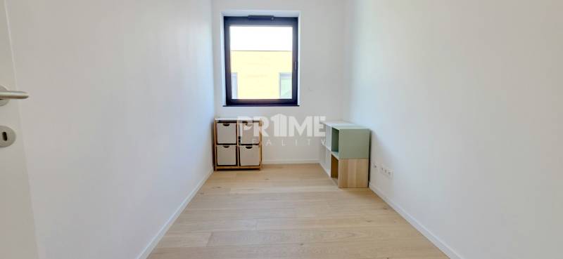 LUXUSNÝ 3i byt,PARKING,CHLADENIE,TERASA,Grand Koliba, Frankovská ulica - Jednoduchá izba s drevenou podlahou a oknom v 3-izbovom byte.