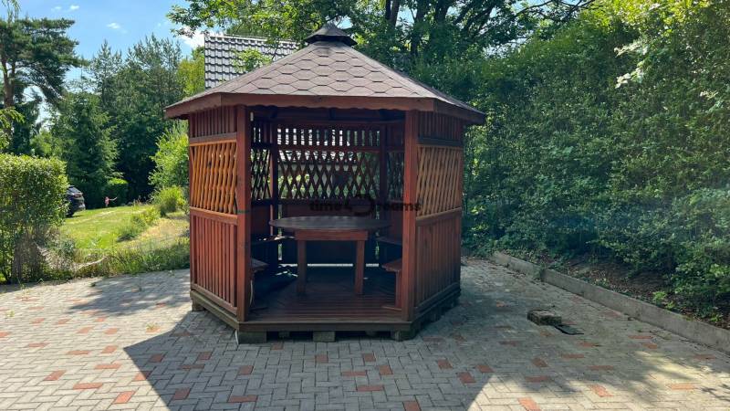 NA PREDAJ Chata na Duchonke- Prašice - Drevený altánok v záhrade chaty v Prašiciach s okolím plným zelene.