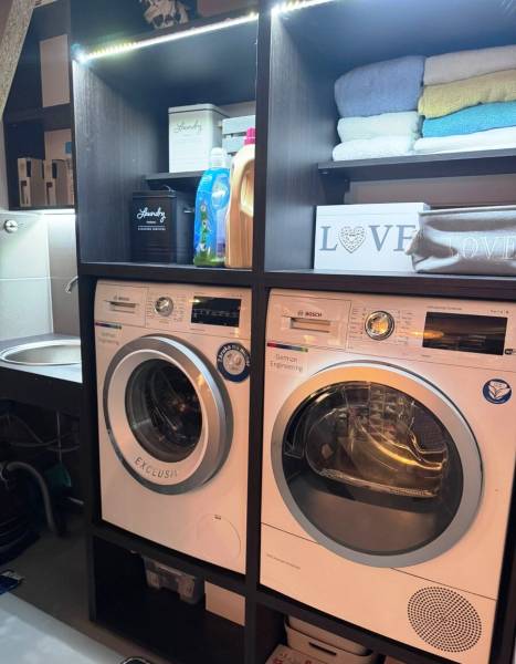 Priestranný 5-izbový rodinný dom s pohodlným dojazdom do Bratislavy  - Práčovňa v rodinnom dome s práčkou, sušičkou, regálom a čistiacimi prostriedkami.