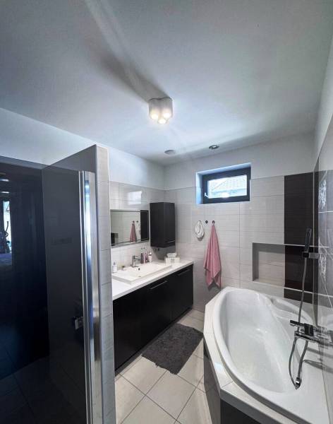 Priestranný 5-izbový rodinný dom s pohodlným dojazdom do Bratislavy  - Kúpeľňa v rodinnom dome s vaňou, umývadlom a skriňami na uskladnenie.