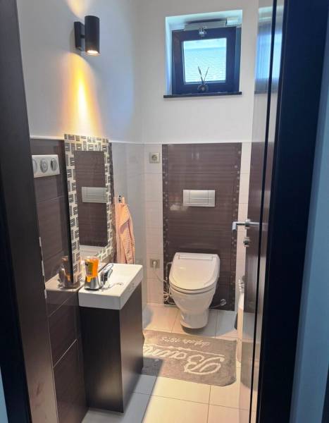 Priestranný 5-izbový rodinný dom s pohodlným dojazdom do Bratislavy  - Kúpeľňa v rodinnom dome s modernými obkladmi, malým umývadlom a štýlovou toaletou.