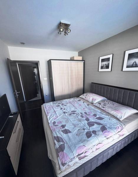 Priestranný 5-izbový rodinný dom s pohodlným dojazdom do Bratislavy  - Spálňa v rodinnom dome s tmavou podlahou, šedým čelom postele a dvomi obrazmi.