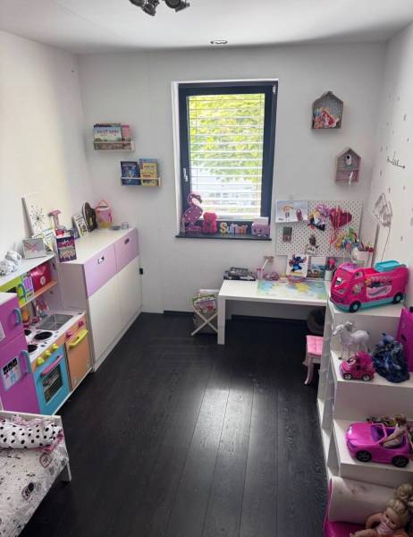 Priestranný 5-izbový rodinný dom s pohodlným dojazdom do Bratislavy  - Detská izba v rodinnom dome s hračkami a podlahou s dreveným dekorom.