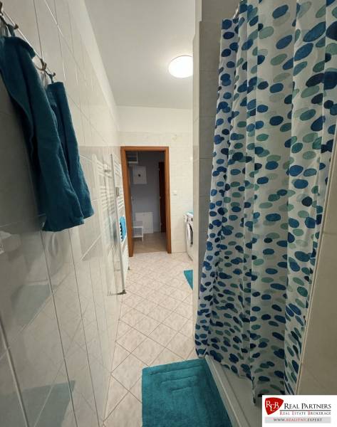 Prenájom 2-izb byt v uzavretom areáli Bratislava II - Kúpeľňa v 2-izbovom byte s vaňou, modrými doplnkami a práčkou.