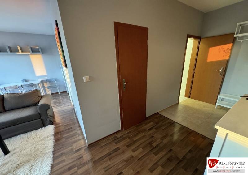 Prenájom 2-izb byt v uzavretom areáli Bratislava II - Chodba v 2-izbovom byte, podlaha s dreveným dekorom, dvere, pohľad do obývacieho priestoru.