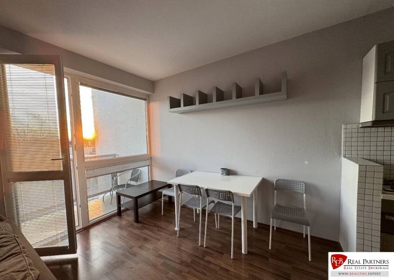 Prenájom 2-izb byt v uzavretom areáli Bratislava II - Obývacia izba v 2-izbovom byte s podlahou s dreveným dekorom a jedálenským setom.