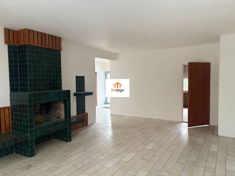 PREDAJ - Rodinný dom s investičným potenciálom - Nové Zámky - Interiér rodinného domu s krbom a podlahou s dreveným dekorom.