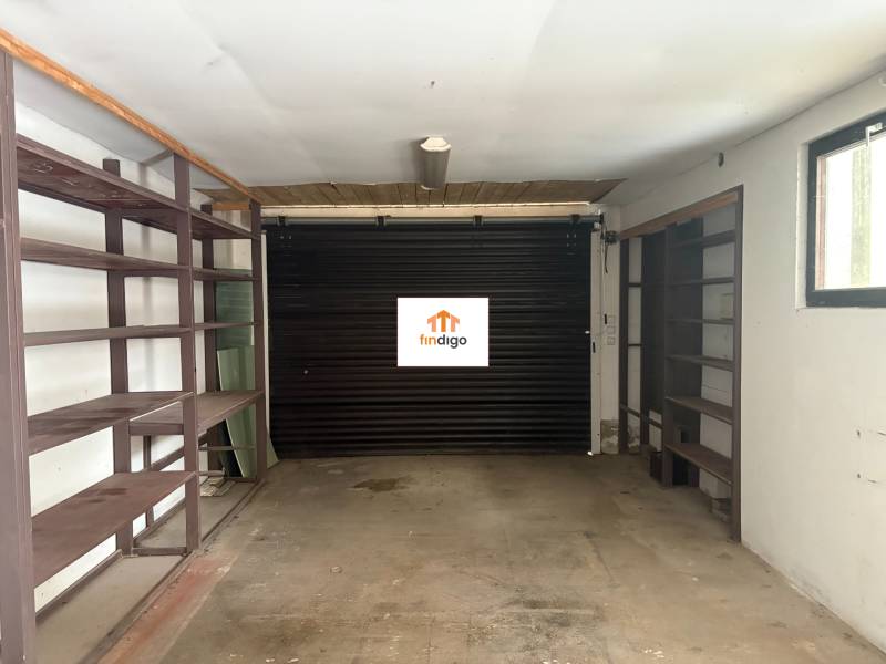 PREDAJ - Rodinný dom s investičným potenciálom - Nové Zámky - Garáž v rodinnom dome s policami a rolovacími dverami.