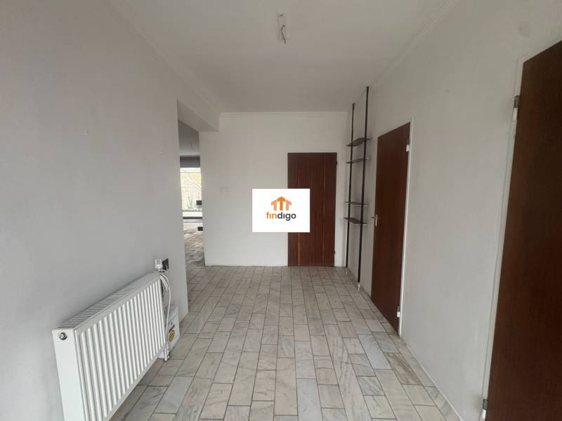 PREDAJ - Rodinný dom s investičným potenciálom - Nové Zámky - Interiér rodinného domu s bielymi stenami, radiátorom a podlahou so svetlým dekorom.