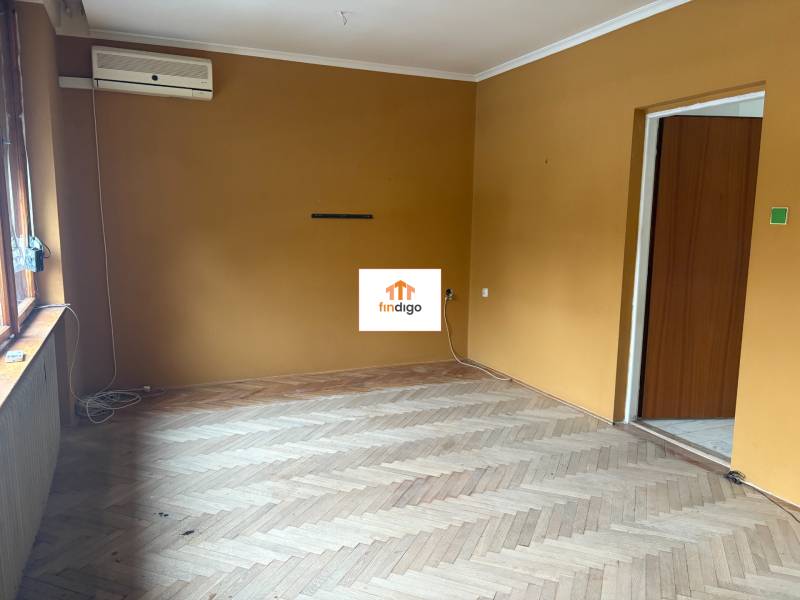 PREDAJ - Rodinný dom s investičným potenciálom - Nové Zámky - Izba s horčicovými stenami, podlaha s dreveným dekorom, klimatizácia v rodinnom dome.