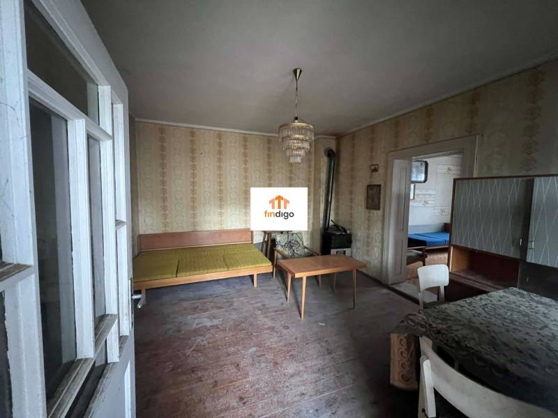 PREDAJ - Rodinný dom na rekonštrukciu s veľkým pozemkom – Kuraľany - Izba v rodinnom dome s retro nábytkom, tapetami a podlahou s dreveným dekorom.