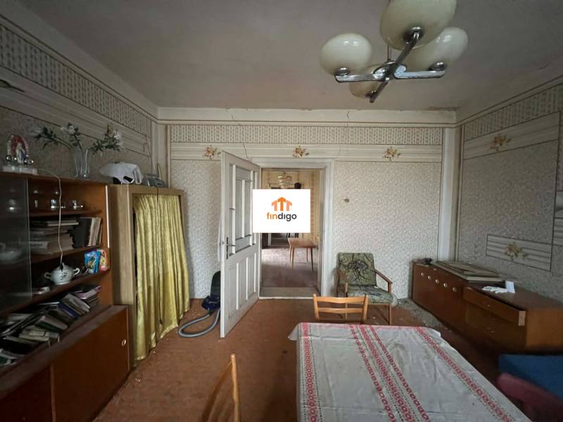 PREDAJ - Rodinný dom na rekonštrukciu s veľkým pozemkom – Kuraľany - Obývačka v rodinnom dome s retro nábytkom a tapetami.