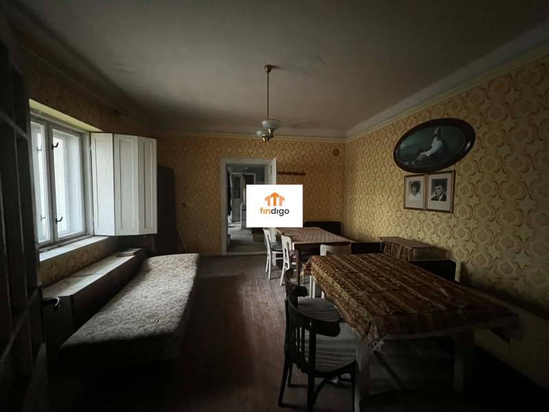 PREDAJ - Rodinný dom na rekonštrukciu s veľkým pozemkom – Kuraľany - Interiér rodinného domu s tapetami, jedálenským stolom a lavičkou pri okne.