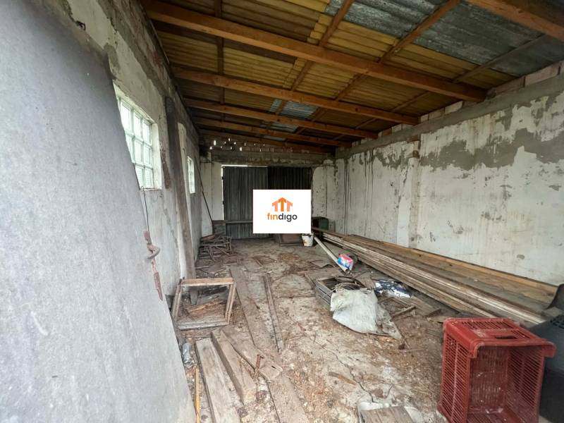 PREDAJ - Rodinný dom na rekonštrukciu s veľkým pozemkom – Kuraľany - Neudržiavaná miestnosť s drevenými trámami a zanedbaným vybavením v rodinnom dome.