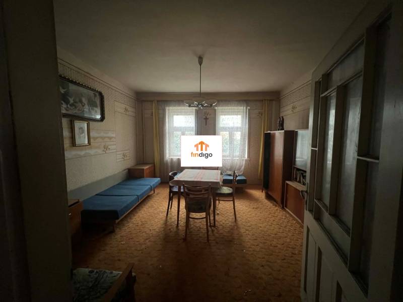 PREDAJ - Rodinný dom na rekonštrukciu s veľkým pozemkom – Kuraľany - Obývacia izba v rodinnom dome s koberecom a historickým nábytkom.