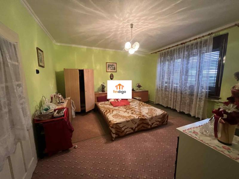 PREDAJ - Rodinný dom v obci Kamenica nad Hronom – len 5 km od Štúrova - Spálňa v rodinnom dome s kobercovou podlahou, posteľou, komodami a svetlozelenými stenami.