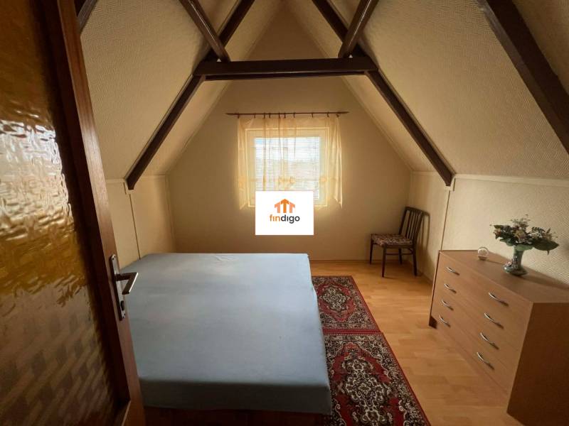 PREDAJ - Zrekonštruovaná rekreačná chata - Chľaba - Podkrovná izba v chate s posteľou, komodou, stoličkou a veľkým kobercom.