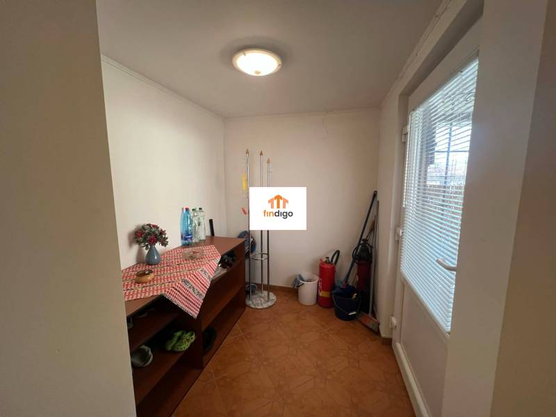 PREDAJ - Zrekonštruovaná rekreačná chata - Chľaba - Interiér chaty s komodou, čistiacimi potrebami a kvetinou na stole.