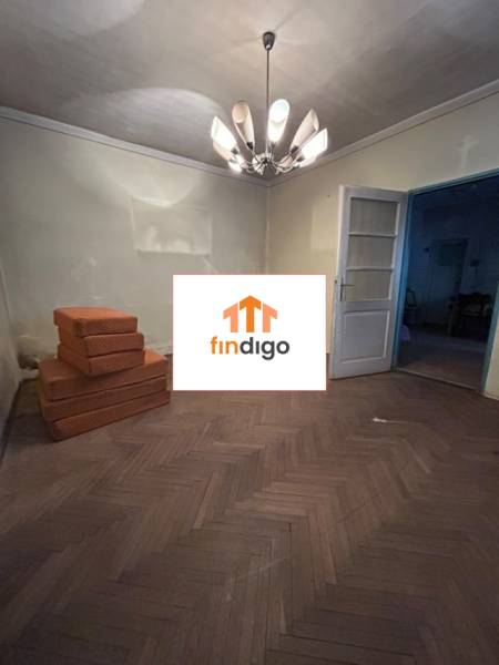 PREDAJ - Rodinný dom s veľkým pozemkom v obci Koplotovce  - Izba v rodinnom dome s lustrami a podlahou s dreveným dekorom, vedľa sú matrace.