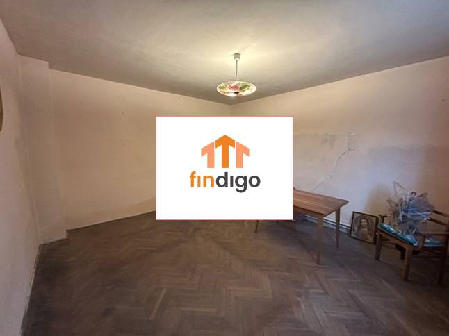 PREDAJ - Rodinný dom s veľkým pozemkom v obci Koplotovce  - Izba v rodinnom dome s podlahou s dreveným dekorom, stolom a stoličkami.