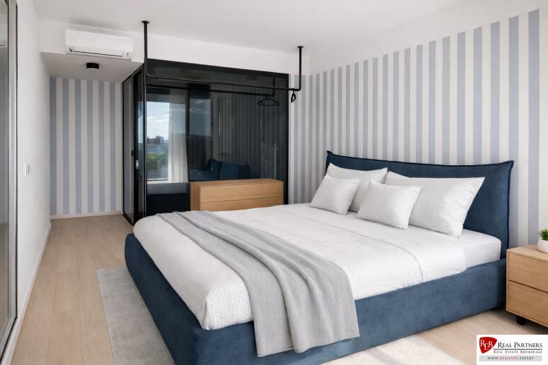 Prenájom 2-izbový byt s loggiou,55m2, EUROVEA TOWER - Spálňa v 2-izbovom byte s pruhovanou tapetou a podlahou s dreveným dekorom.