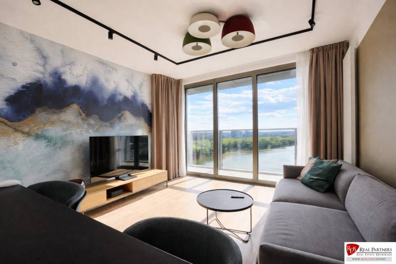 Prenájom 2-izbový byt s loggiou,55m2, EUROVEA TOWER - Obývačka v 2-izbovom byte s výhľadom na rieku a podlahou s dreveným dekorom.