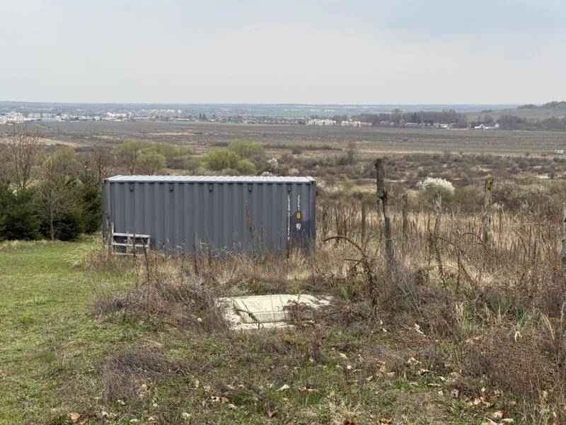 Oplotený obrábaný vinohrad so studňou a kontajnerom. - Kontajner na tráve s výhľadom na okolie na Rekreačných pozemkoch vo Fajgalskej ceste, Pezinok.