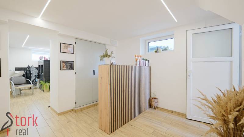 TOP - Rodinný dom s veľkým pozemkom - Dolný Hričov - Interiér rodinného domu s priestrannou miestnosťou, recepciou a podlahou s dreveným dekorom.