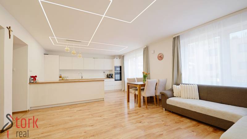 TOP - Rodinný dom s veľkým pozemkom - Dolný Hričov - Interiér rodinného domu s kuchyňou a obývačkou, podlahou s dreveným dekorom a svetlým nábytkom.