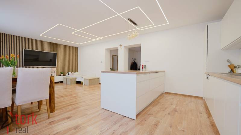 TOP - Rodinný dom s veľkým pozemkom - Dolný Hričov - Kuchyňa a obývačka s podlahou s dreveným dekorom v rodinnom dome.