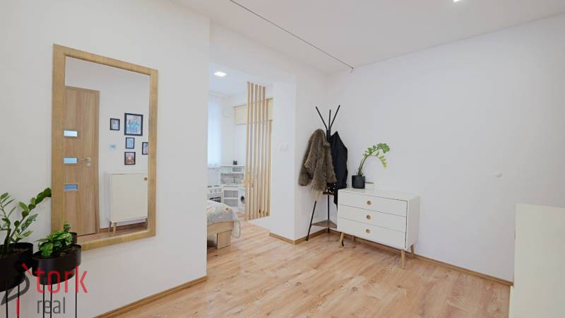 TOP - Rodinný dom s veľkým pozemkom - Dolný Hričov - Interiér rodinného domu s podlahou s dreveným dekorom, komodou a stojanom na kabáty.