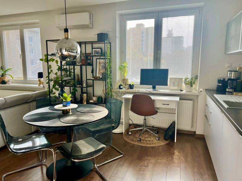 Prenájom 2,5 izbový byt, Trenčianska ulica, Bratislava II. Ružinov - Jedáleň s okrúhlym stolom, pracovný kút a podlaha s dreveným dekorom v 2-izbovom byte.