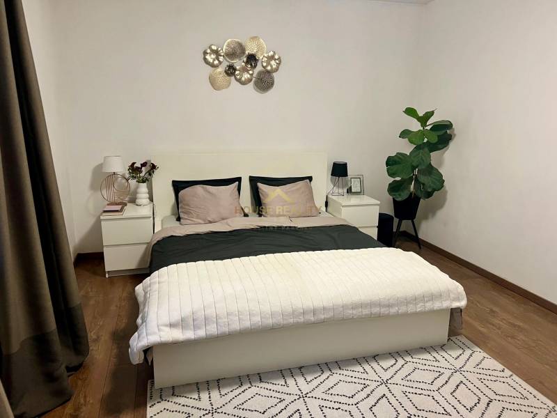 Prenájom 2,5 izbový byt, Trenčianska ulica, Bratislava II. Ružinov - Spálňa s posteľou, dvoma nočnými stolíkmi a rastlinou v 2-izbovom byte.