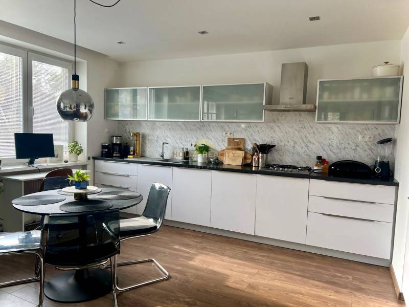 Prenájom 2,5 izbový byt, Trenčianska ulica, Bratislava II. Ružinov - Kuchyňa v 2-izbovom byte s podlahou s dreveným dekorom a jedálenským stolom.