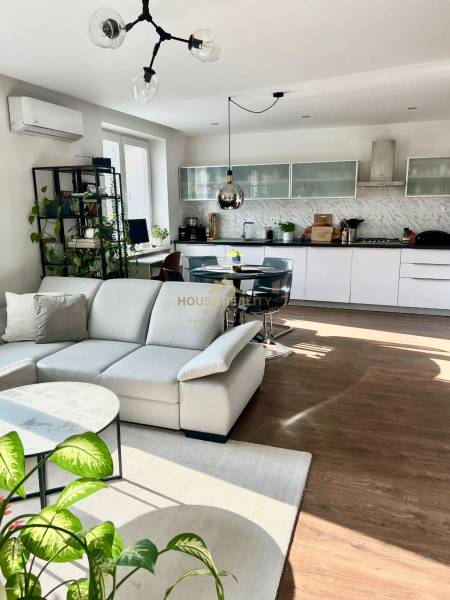 Prenájom 2,5 izbový byt, Trenčianska ulica, Bratislava II. Ružinov - Obývačka s kuchyňou v 2-izbovom byte, svetlý nábytok, podlaha s dreveným dekorom.