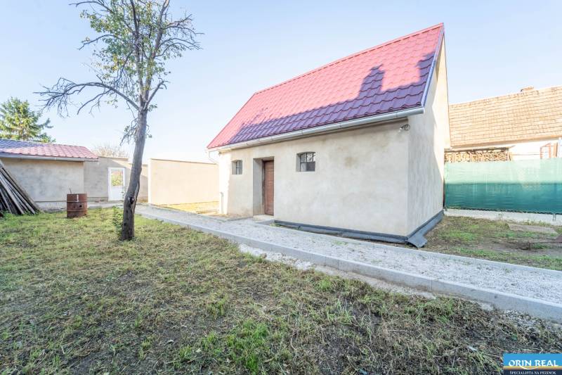 RD PO REKONŠTRUKCII spolu so STAVEBNÝM POZEMKOM na druhý dom - takmer  - Rodinný dom na Kupeckého ulici v Pezinku s červenou strechou a záhradou.