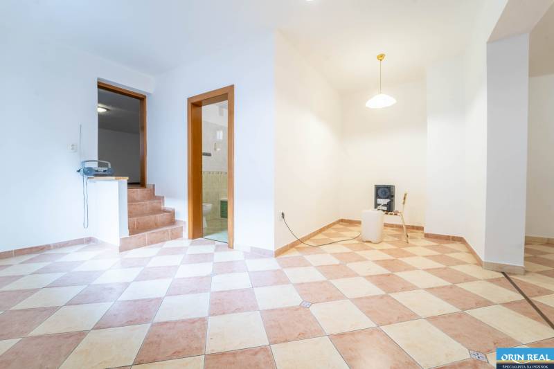 RD PO REKONŠTRUKCII spolu so STAVEBNÝM POZEMKOM na druhý dom - takmer  - Interiér rodinného domu s dlažbou, schodmi, stoličkou a lampou na strope.