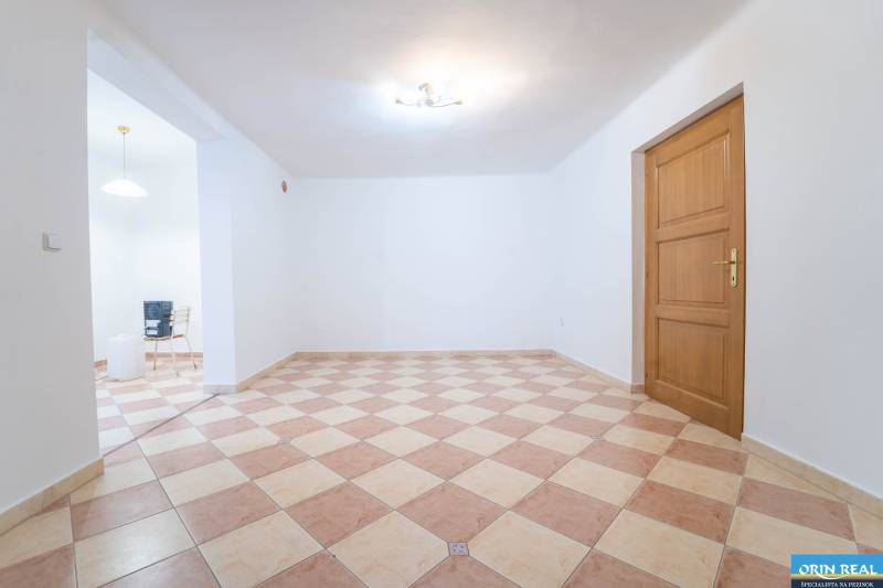 RD PO REKONŠTRUKCII spolu so STAVEBNÝM POZEMKOM na druhý dom - takmer  - Prázdna izba v rodinnom dome s dlažbou a drevenými dverami.