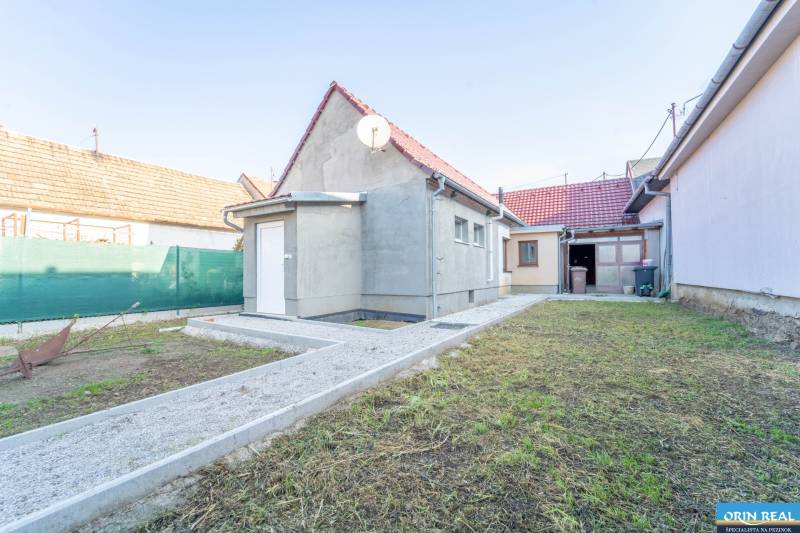 RD PO REKONŠTRUKCII spolu so STAVEBNÝM POZEMKOM na druhý dom - takmer  - Rodinný dom na Kupeckého ulici v Pezinku s dvorom pokrytým trávnikom.