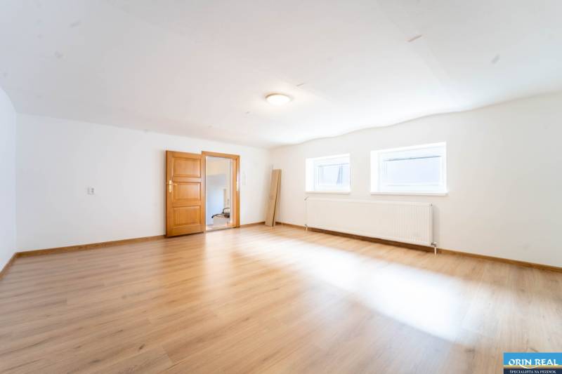 RD PO REKONŠTRUKCII spolu so STAVEBNÝM POZEMKOM na druhý dom - takmer  - Priestranná izba v rodinnom dome s podlahou s dreveným dekorom a dvoma oknami.