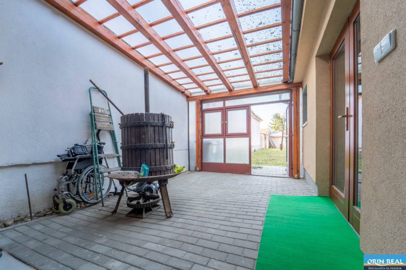 RD PO REKONŠTRUKCII spolu so STAVEBNÝM POZEMKOM na druhý dom - takmer  - Zastrešená terasa v rodinnom dome s vínnym lisom a výhľadom do záhrady.