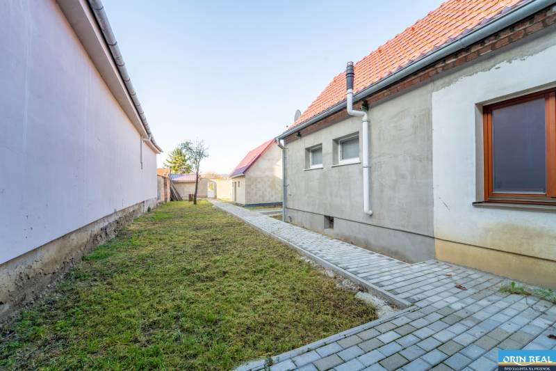 RD PO REKONŠTRUKCII spolu so STAVEBNÝM POZEMKOM na druhý dom - takmer  - Dvor rodinného domu na Kupeckého ulici v Pezinku so spevnenou dlažbou.