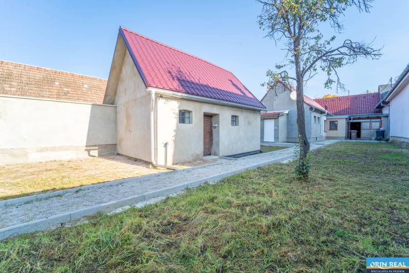 RD PO REKONŠTRUKCII spolu so STAVEBNÝM POZEMKOM na druhý dom - takmer  - Rodinný dom na Kupeckého ulici v Pezinku s trávnikom a štrkovým chodníkom.