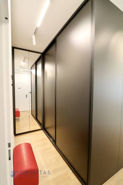 Komfortne vybavený 2-izbový byt v projekte 2 Sýpky - Chodba s čiernymi skriňami, zrkadlom a podlahou s dreveným dekorom v 2-izbovom byte.